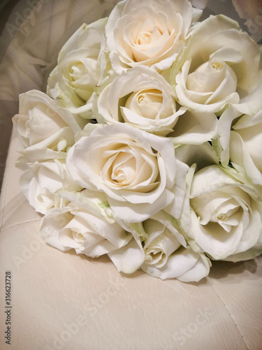 Bouquet of white roses on a leather chair