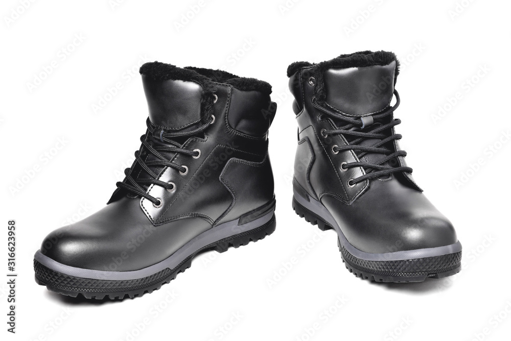 Winter men’s black leather boots on a white background, hiking shoes, practical off-road shoes, close-up i