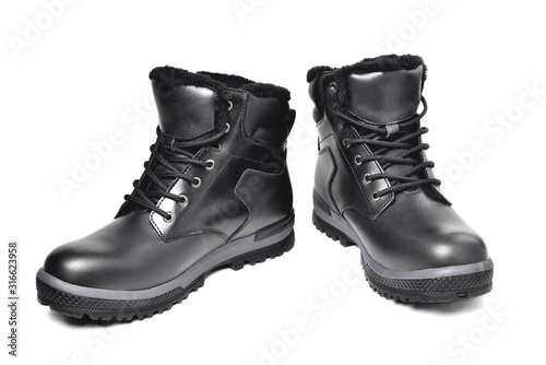 Winter men’s black leather boots on a white background, hiking shoes, practical off-road shoes, close-up i
