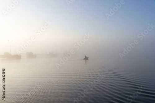  foggy sea sunrise with fisherman in boat 