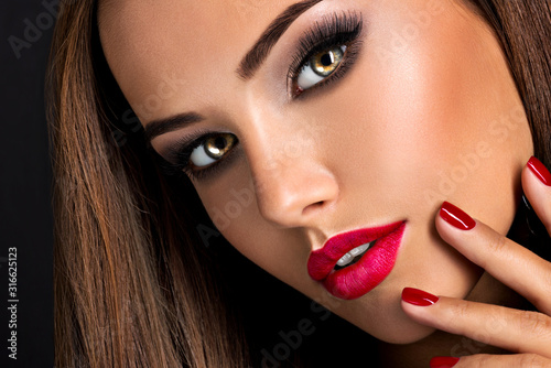 Photo seductive woman with dark brown eye makeup and bright red lips and nails