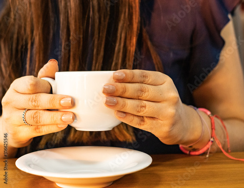 Mujer independiente con hermosas manos, tomando una taza de café