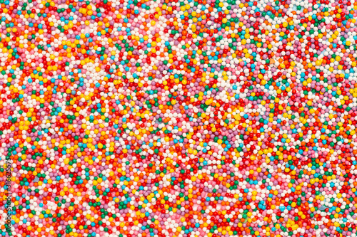 Multicolored round confetti topping for sweets, colorful macro background. Tasty sweets and desserts