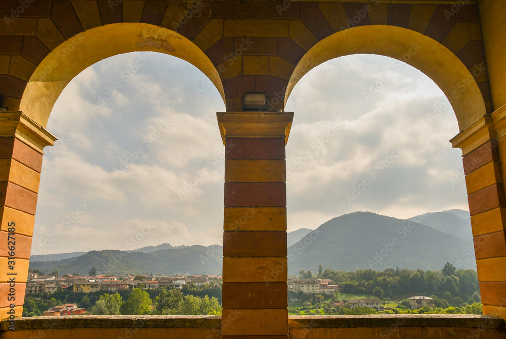 Panoramic view of the mountains of the Maira Valley in Piedmont from the arches of the Civic Theatre of Dronero, Cuneo, Italy