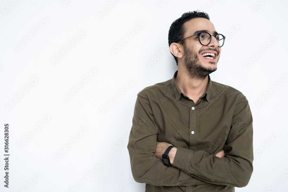 Laughing guy in eyeglasses and casualwear crossing arms on chest Laughing guy in eyeglasses and casualwear crossing arms on chest