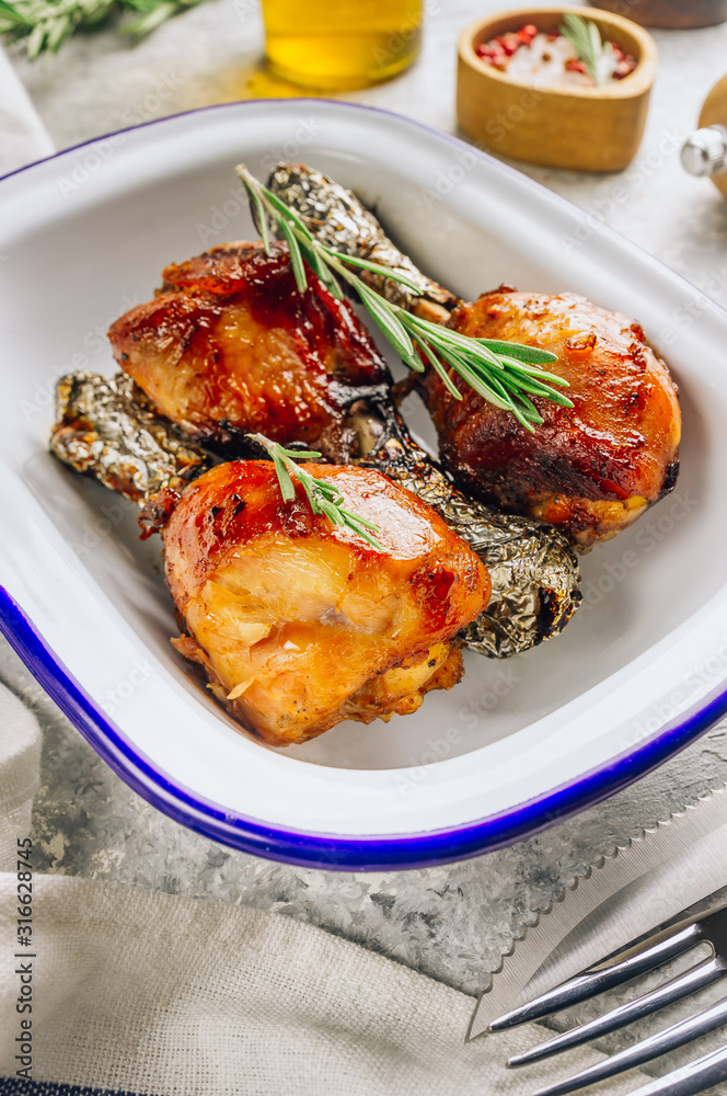 Grilled chicken drumstick bbq with rosemary on a stone gray background. Grilled chicken drumstick bbq with rosemary on a stone gray background.