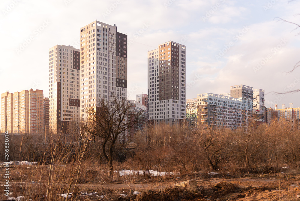New districts of Moscow. Skyscrapers in Kommunarka. High-rise residential buildings behind an abandoned field.