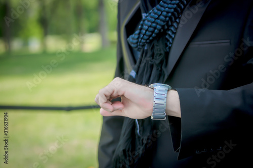 Close-up of man checking the time on wristwatch.