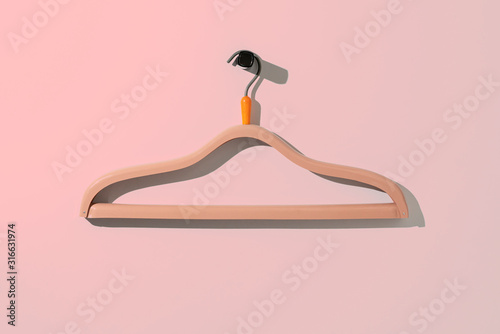 Fotografía a simple empty clothes hanger on the wall hook, fashion cloth textile storage