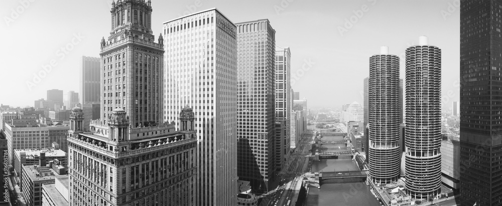 Fototapeta premium To jest widok na rzekę Chicago. Apartamenty Marina Tower, budynek Wrigley i linia horyzontu otaczają rzekę. To jest czarno-białe zdjęcie.
