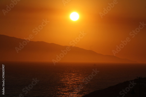 Sunset over the horizon of calm sea © Stavros