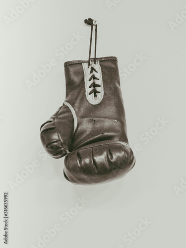 old Boxing glove hangs on wall bw vintage 