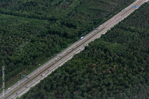 AERIAL, TOP DOWN: Cars and trucks drive on a highway speed road. Flying above busy space for text diagonal symmetry Commuters and travelers driving up and down asphalt road