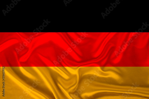 photo of the national flag of Germany on a luxurious texture of satin  silk with waves  folds and highlights  close-up  copy space  travel concept  economy and state policy  illustration