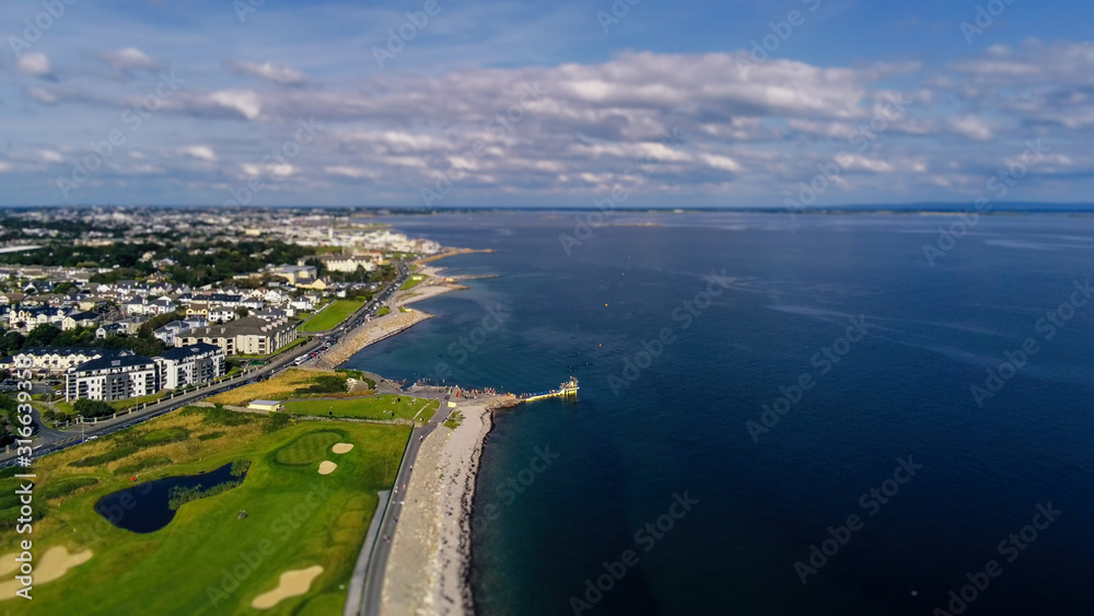 Aerial view, Salthill beach and Blackrock diving board, Tilt shift effect. Warm sunny day, Galway city, Ireland. Cloudy sky.