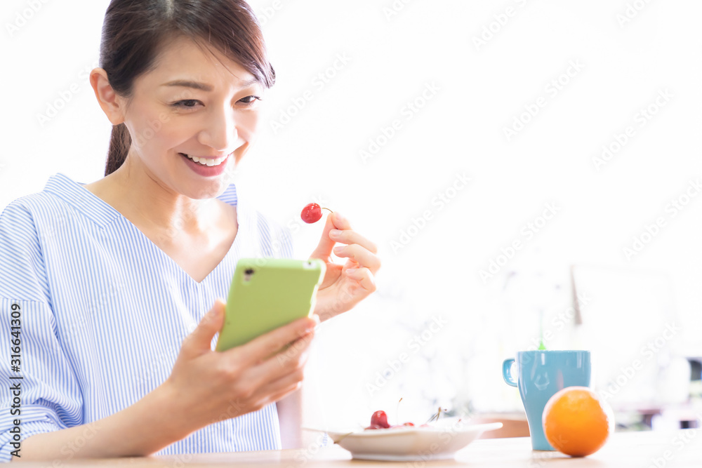 部屋でスマホを見る女性