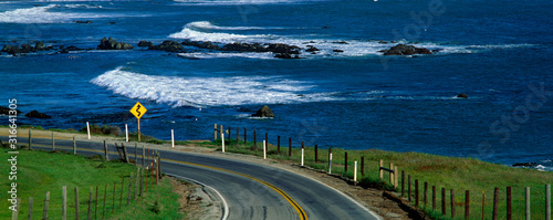 This is Route 1, also known as the Pacific Coast Highway. The ocean is to the right of the road which curves around a bend.