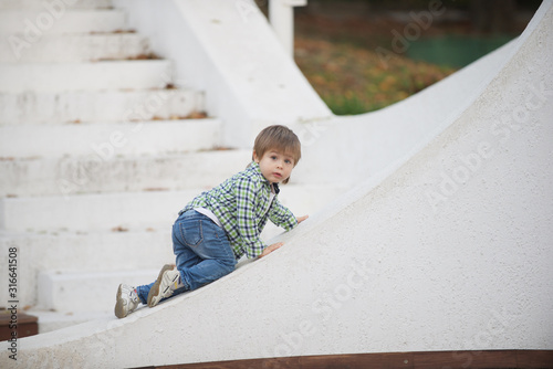 The boy is sitting on a white border. Blurred image