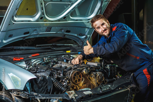 Mechanic working in car motor. Auto repair, Service center. Mechanic with wrench working and repair car engine in car service centre.