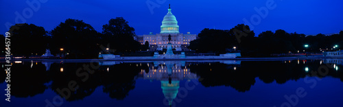 This is the U.S. Capitol set in front of the Capitol reflecting pool at sunset. The image of the U.S. Capitol is reflected in the reflecting pool.