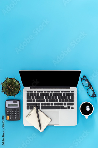 flat lay Office desk table of modern workplace with laptop on blue table, top view laptop background and copy space on black background, blue desk office with laptop, 