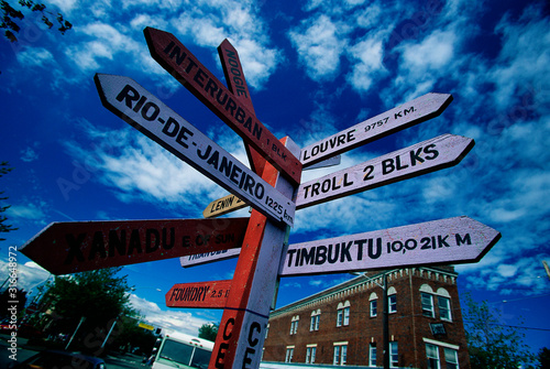 This is the Fremont district with a sign that says welcome to the center of the universe. It also has signs pointing to other famous cities and how many miles it takes to get there. photo