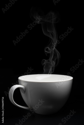 White porcelain cup on black background with steam