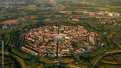 Aerial, reverse, drone shot,overlooking the Palmanova star fortification, at sunset, in Udine, Italy photo