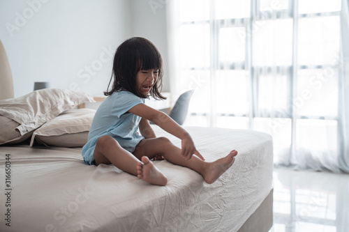 Strong screaming due to a tantrum. child crying on bed