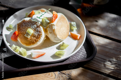 Fluffy Pancakes Toasted with strawberry, kiwi fruit, foaming smoothie served with honey syrup