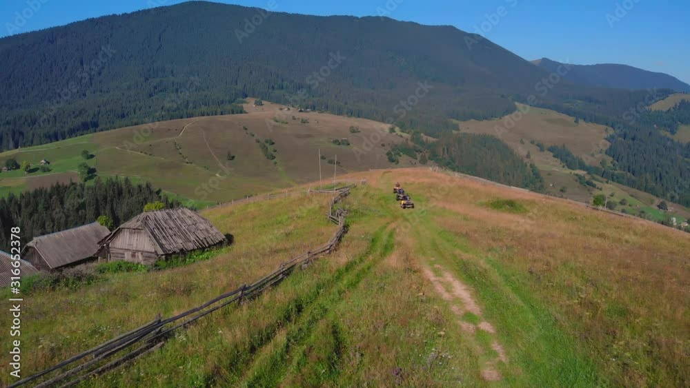 ATV quad bike riders on beautiful mountain background. Aerial view of atv quad bikers on picturesque mountains landscape background. ATV quad bike riders on beautiful mountain background. Aerial view of atv quad bikers on picturesque mountains landscape background.