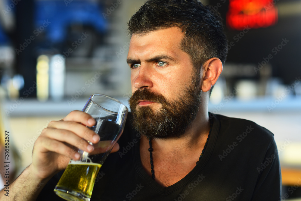 Emotional funny bearded drunk hipster holds craft bottled beer. Bearded man drinking lager beer.