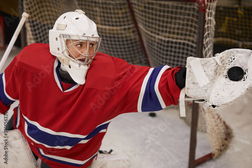 Photography High angle action shot of female hockey player defending gate during match, copy