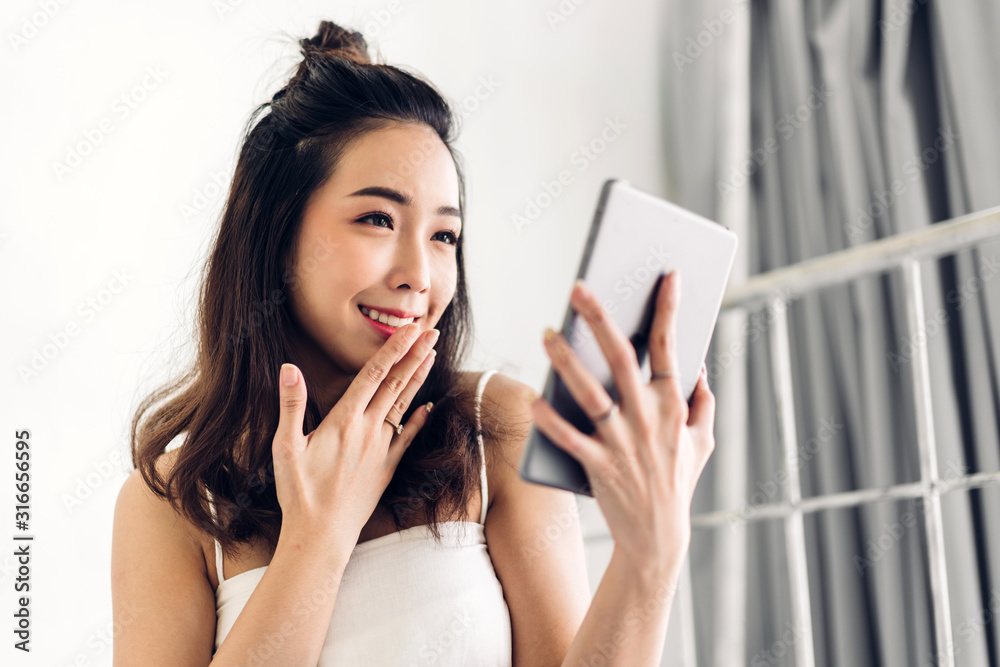 Happy woman relaxing using tablet computer on the bed at home.technology and communication concept Happy woman relaxing using tablet computer on the bed at home.technology and communication concept