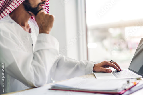 Arabic businessman working with laptop computer.creative arab business people planning at modern work loft photo