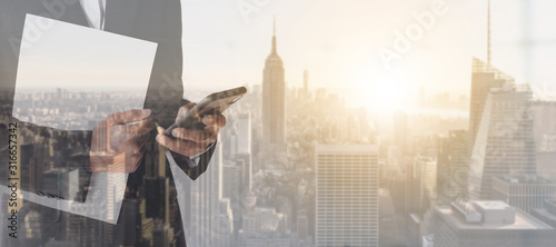 Overlapping images of cities and businessman with Smartphone. Business and technology concept.