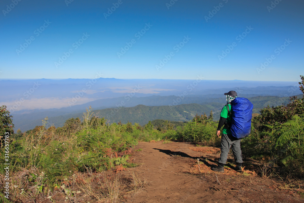 Man hiking Traveler with big backpack mountaineering Travel Lifestyle