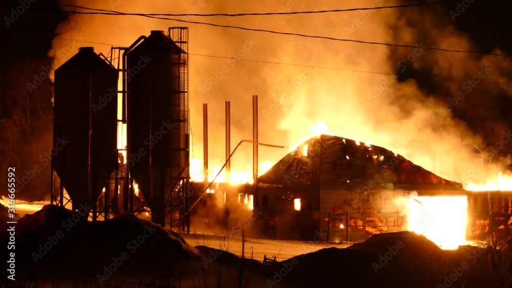 Spectacular building fire at night with snow on the ground at farming complex