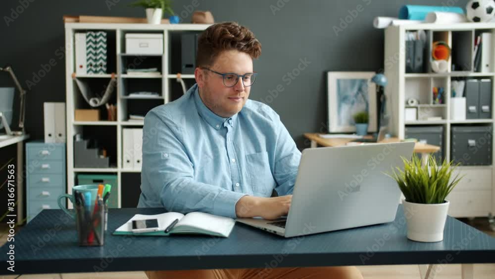 Serious businessperson handsome guy is typing using laptop computer indoors in office room busy with accounting job then writing taking notes in notebook . People and corporate activities concept. Serious businessperson handsome guy is typing using laptop computer indoors in office room busy with accounting job then writing taking notes in notebook . People and corporate activities concept.