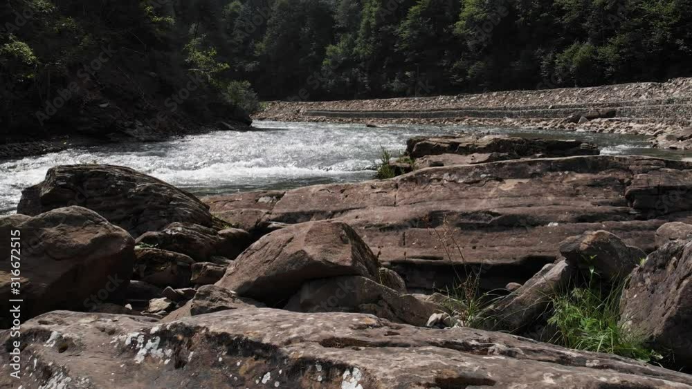 Landscape of mountain river with big boulders on bank. Landscape of mountain river with big stones and forest on a sunny day. Landscape of mountain river with big boulders on bank. Landscape of mountain river with big stones and forest on a sunny day.
