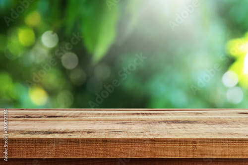 Blurred fresh nature garden background and empty wooden table.