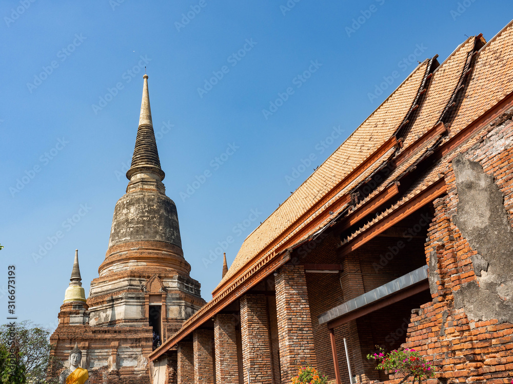 Naklejka premium Thai architecture Ancient times,Most materials are brick and mortar,forming a wall and floor,The surrounding area has a beautiful Buddha statue,On the bright day