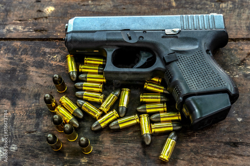 Guns and ammunition placed in a wooden table,Short guns and ammunition placed on a black background table,Guns and ammunition are ready to use.,Noisy weapon