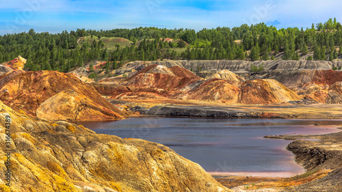 Landscape like a planet Mars surface. Ural refractory clay quarries. Nature of Ural mountains, Russia. Solidified red-brown black Earth surface for screensaver for desktop, banner, cover.