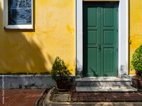 Thai architecture is influenced by Europe,Yellow wall And Green door Unique pattern of Thailand,Texture wall color Stain