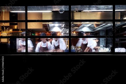 many chefs busy cooking in kitchen photo