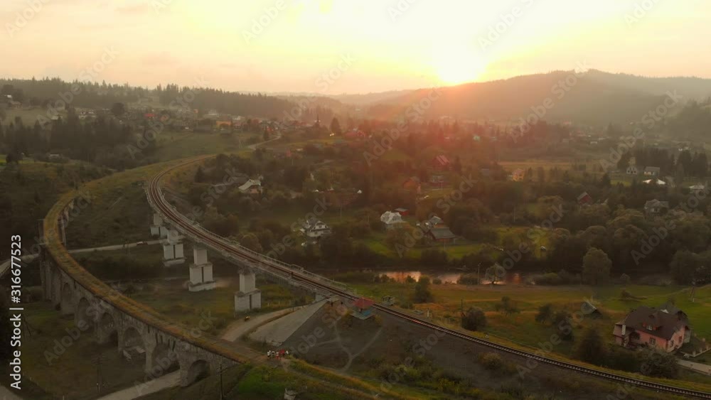 Picturesque alpine landscape with an old railway bridge. Old and new railway bridges in Village of Vorokhta, Ukraine. Beautiful rural landscape at sunset. Picturesque alpine landscape with an old railway bridge. Old and new railway bridges in Village of Vorokhta, Ukraine. Beautiful rural landscape at sunset.