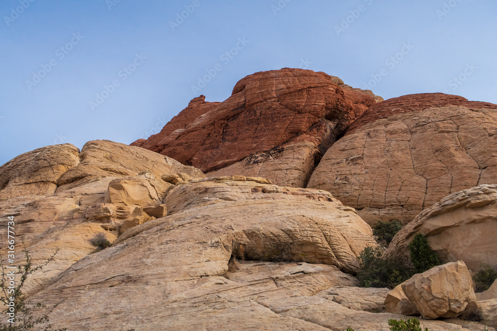Low angle landscape of massive white and red rock formations or hills at Red Rock Canyon in Las Vegas, Nevada