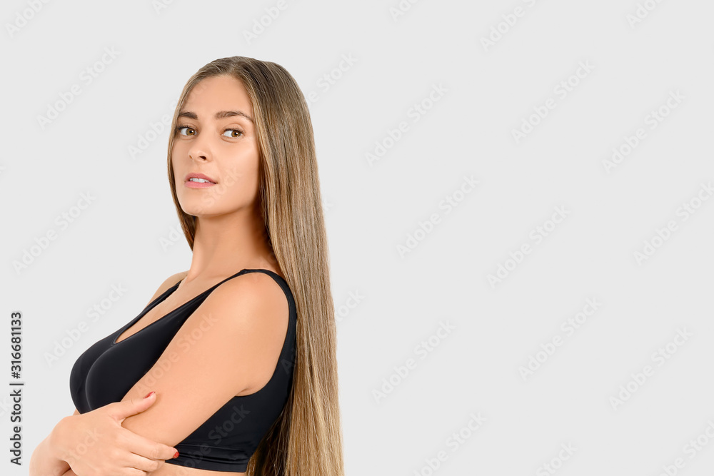 Young beautiful brown-haired girl with long hair dressed in a dark blue T-shirt posing on camera in the studio. There is a place for your text in the image Young beautiful brown-haired girl with long hair dressed in a dark blue T-shirt posing on camera in the studio. There is a place for your text in the image