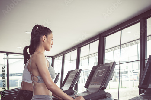 Side view of two attractive sports women on running track. Girls on treadmill. photo of muscular woman in sportswear. strength and motivation. concept of healthy lifestyle.
